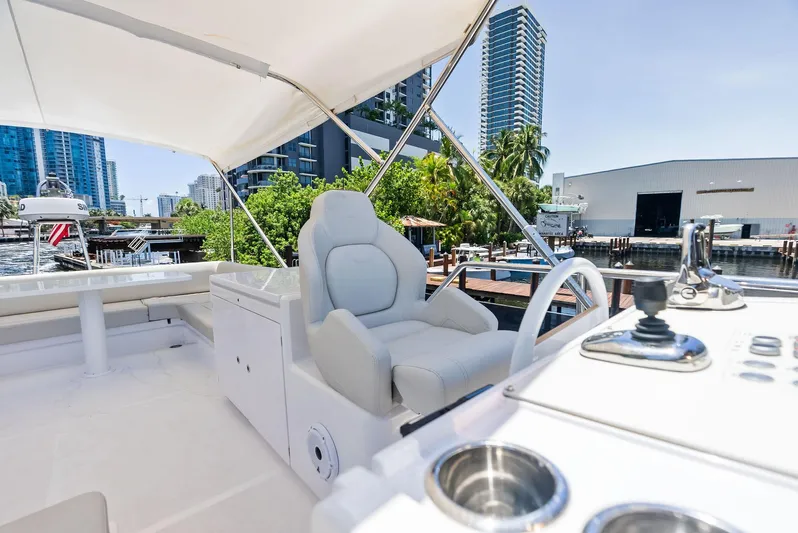 Ferretti 500 Yacht Photos Pics 2024 Ferretti Yachts 500 flybridge with luxurious seating and modern controls, docked in urban marina.