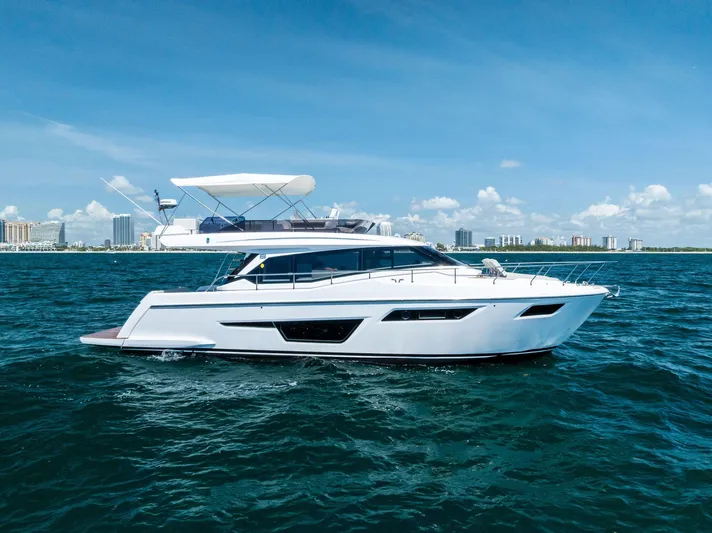 Ferretti 500 Yacht Photos Pics 2024 Ferretti Yachts 500 cruising on blue ocean with city skyline in background.