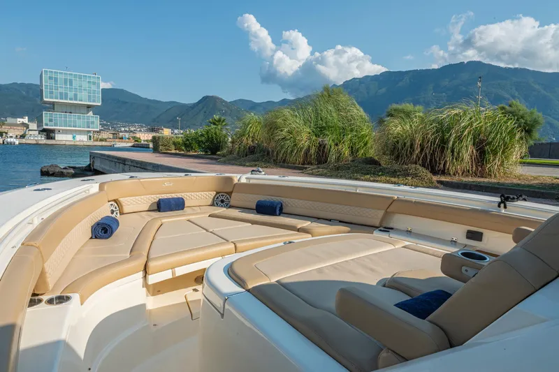  Yacht Photos Pics Luxurious 2023 Scout 425 LXF boat interior with plush seating, docked by scenic mountains.