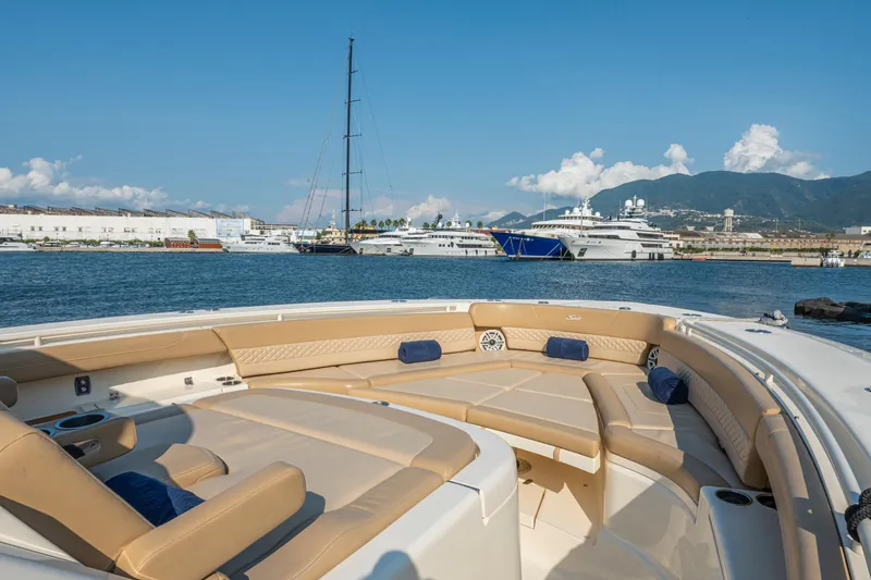  Yacht Photos Pics Luxurious 2023 Scout 425 LXF boat with spacious seating, docked in a scenic marina.