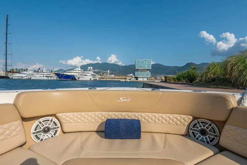  Yacht Photos Pics 2023 Scout 425 LXF boat interior with luxurious seating, docked near yachts and scenic mountains.