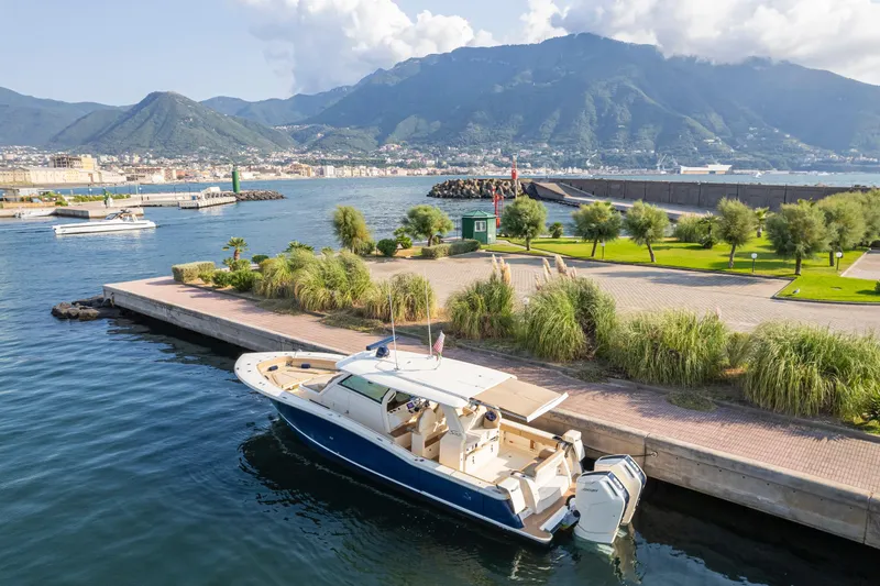  Yacht Photos Pics 2023 Scout 425 LXF boat docked in scenic harbor with mountains in background.