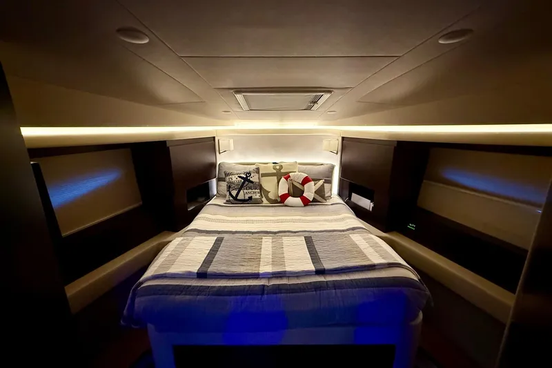 Yacht Photos Pics Luxurious bedroom interior of 2018 Regal 42 Grande Coupe yacht, featuring elegant bedding and ambient lighting.