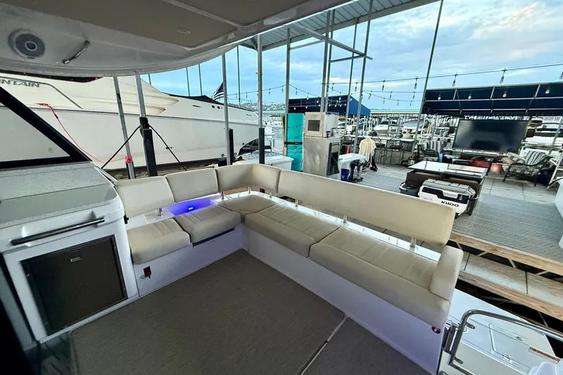  Yacht Photos Pics Luxurious seating area on a 2018 Regal 42 Grande Coupe yacht at a marina.