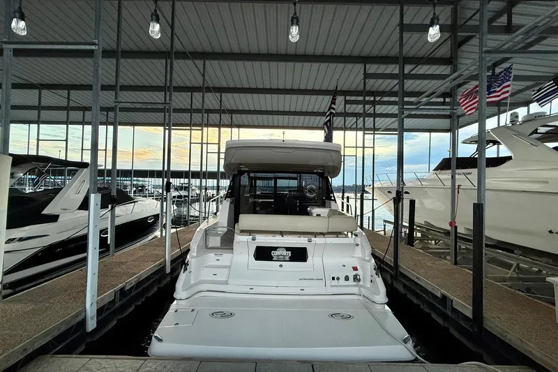 Yacht Photos Pics 2018 Regal 42 Grande Coupe docked in a marina with covered roof and flags.