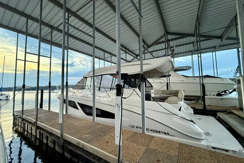  Yacht Photos Pics 2018 Regal 42 Grande Coupe docked under a covered marina with scenic water view.