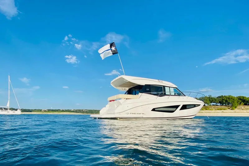  Yacht Photos Pics 2018 Regal 42 Grande Coupe yacht on calm water under clear blue sky.