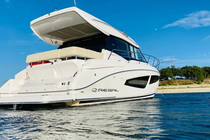  Yacht Photos Pics 2018 Regal 42 Grande Coupe yacht on calm water under clear blue sky.