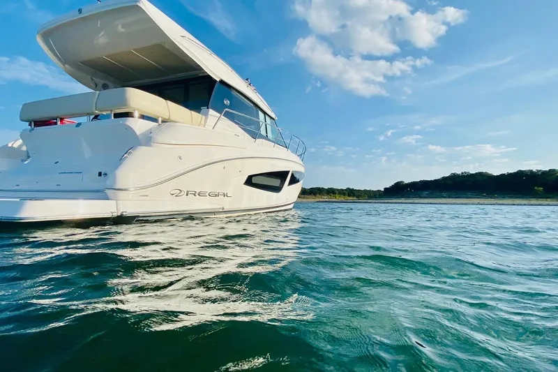  Yacht Photos Pics 2018 Regal 42 Grande Coupe yacht on serene water under a clear blue sky.
