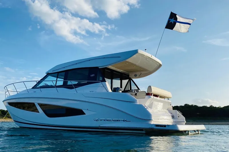  Yacht Photos Pics 2018 Regal 42 Grande Coupe yacht on water, blue sky, flag waving.