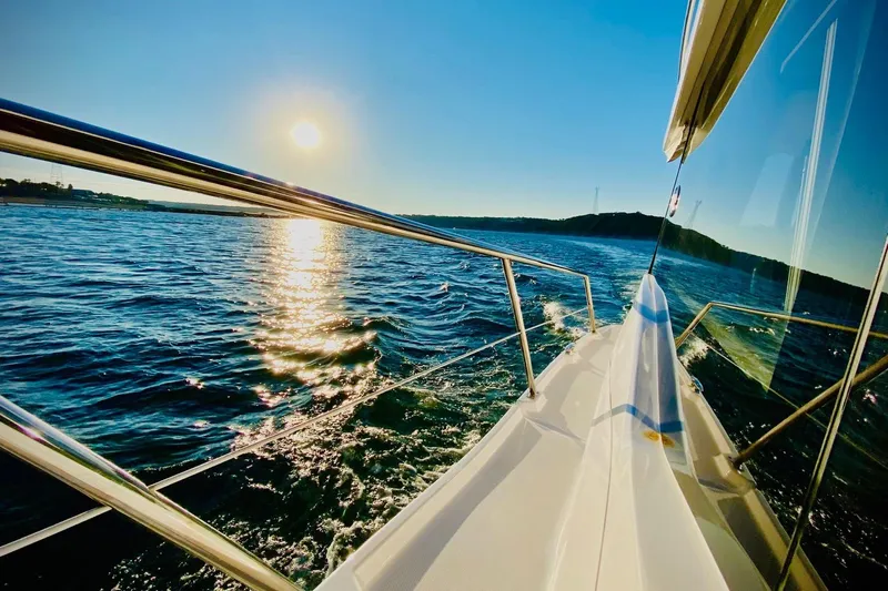  Yacht Photos Pics 2018 Regal 42 Grande Coupe cruising on sunny waters, reflecting sunlight.