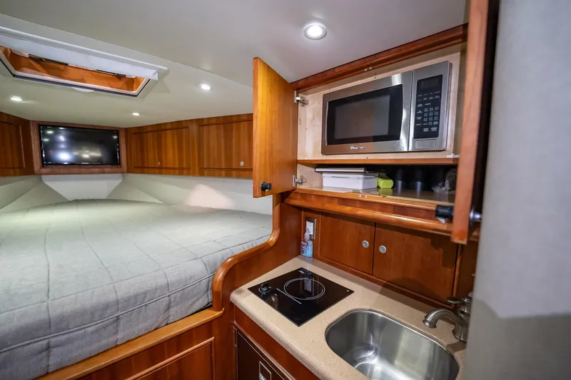Here Fishy Fishy Yacht Photos Pics Interior of 2012 Winter Custom Yachts 38 Express with kitchenette and bed.