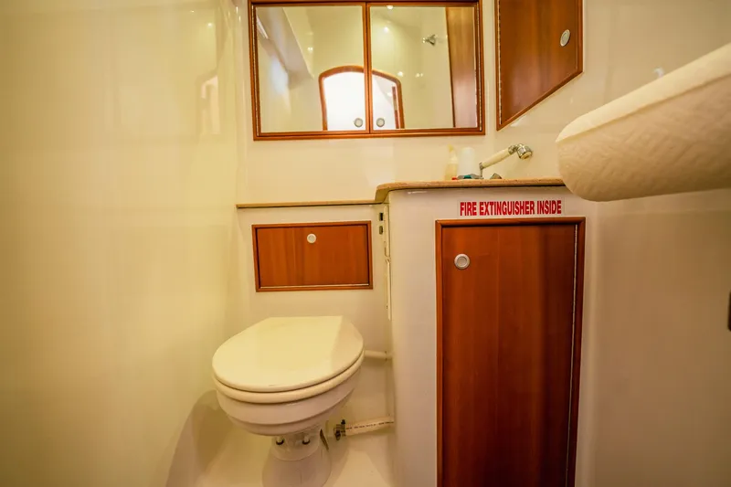 Here Fishy Fishy Yacht Photos Pics 2012 Winter Custom Yachts 38 Express bathroom with wooden cabinets and a toilet.