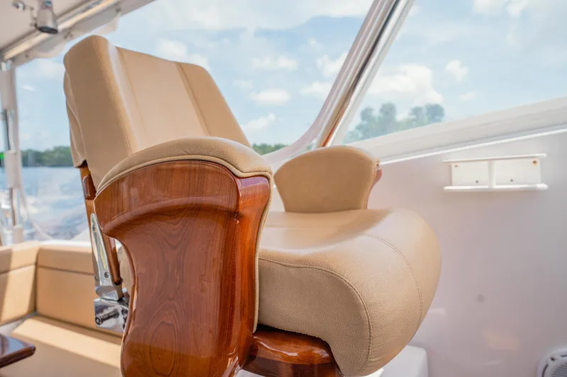 Here Fishy Fishy Yacht Photos Pics Luxurious helm chair on 2012 Winter Custom Yachts 38 Express, featuring elegant wood and leather design.