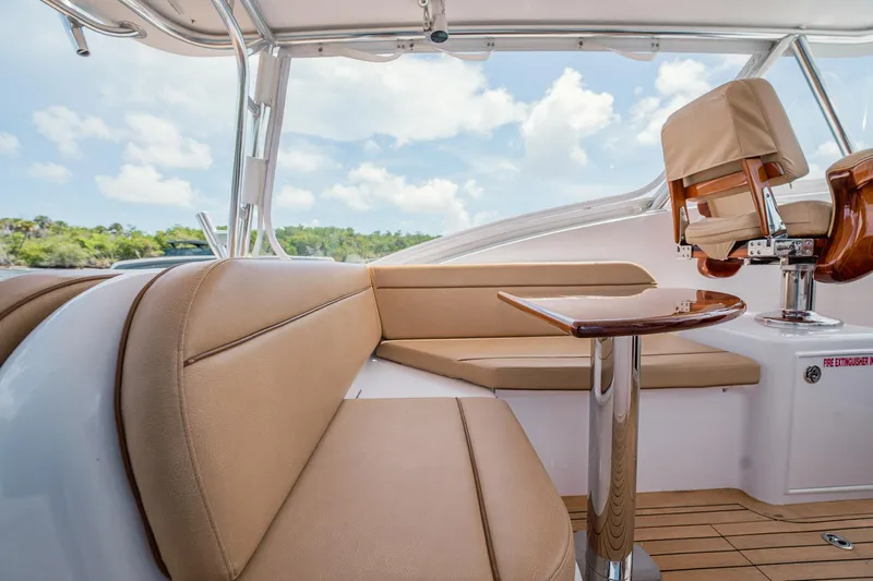 Here Fishy Fishy Yacht Photos Pics Luxurious interior of 2012 Winter Custom Yachts 38 Express with beige seating and wooden table.