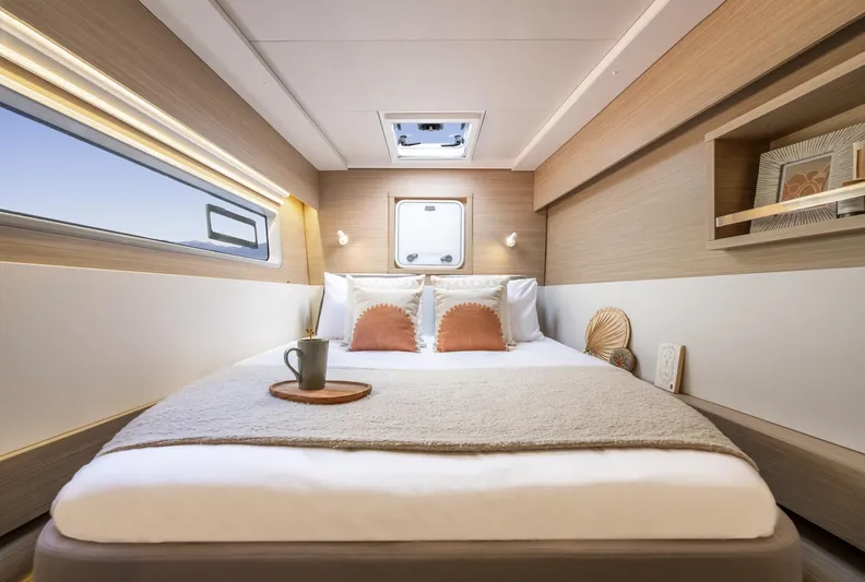  Yacht Photos Pics Luxurious cabin interior of 2026 Lagoon 43 yacht with cozy bed and modern decor.