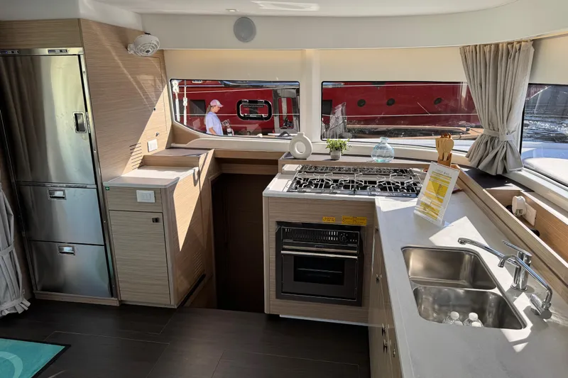  Yacht Photos Pics Modern kitchen interior of 2026 Lagoon 43 yacht with stainless steel appliances and sleek countertops.