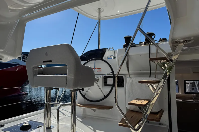  Yacht Photos Pics Helm station of 2026 Lagoon 43 yacht with steering wheel and steps.