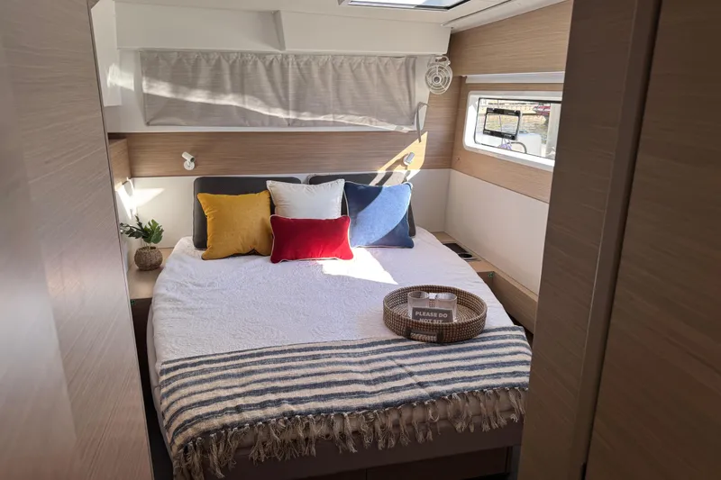  Yacht Photos Pics Luxurious bedroom interior of 2026 Lagoon 43 yacht with cozy bedding and natural light.