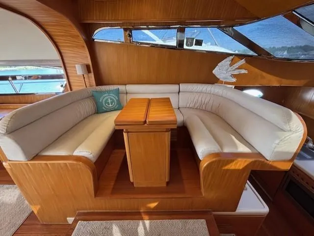 Marsea Yacht Photos Pics Luxurious yacht interior with curved seating, wooden table, and nautical decor, Johnson High Tech Euro 56, 1994.