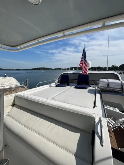 Marsea Yacht Photos Pics Luxury yacht deck with seating, American flag, and scenic waterfront view. Johnson High Tech Euro 56, 1994.