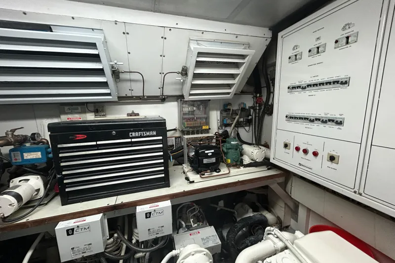 Gabriela G Yacht Photos Pics Engine room of a 2001 Mangusta 72 yacht with control panels and tool storage.