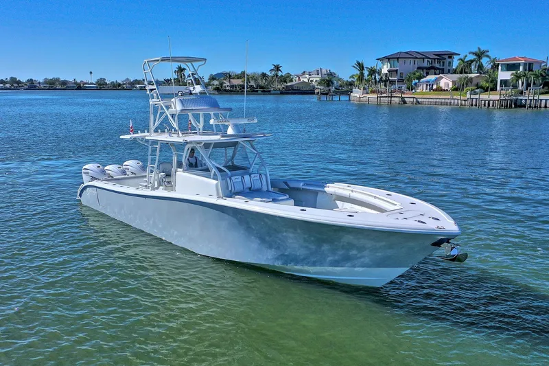 Contingensea Yacht Photos Pics 2015 Yellowfin 42 Offshore boat on calm water near waterfront homes.