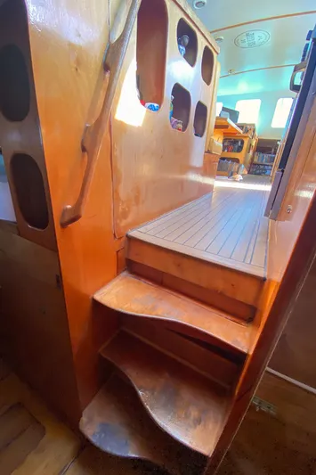  Yacht Photos Pics Wooden interior stairs on a 2004 Custom BBL 54' boat, leading to a sunlit cabin.