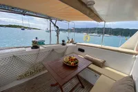 Luxurious 2004 Custom BBL 54' yacht deck with fruit bowl, overlooking serene marina.