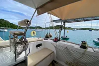 Custom BBL 54' yacht interior with scenic ocean view, anchored boats, and lush green hills.