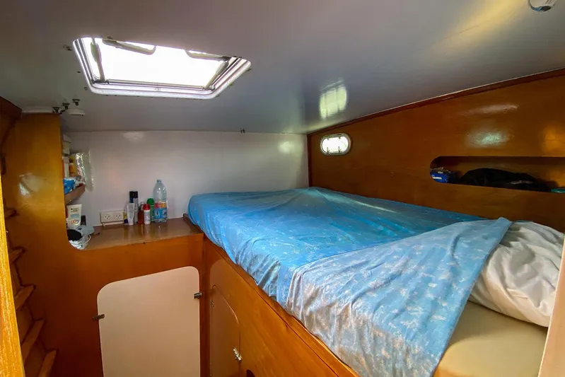  Yacht Photos Pics Cozy cabin interior of 2004 Custom BBL 54' boat with blue bedding and wooden finish.