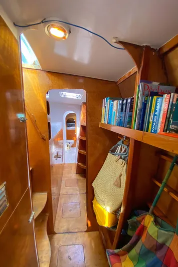  Yacht Photos Pics Cozy wooden yacht interior with bookshelves, colorful hammock, and natural lighting. Custom BBL 54', 2004.