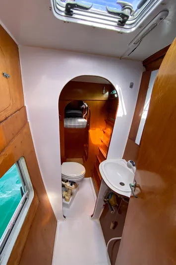  Yacht Photos Pics Compact bathroom in 2004 Custom BBL 54' boat with wooden accents and porthole window.