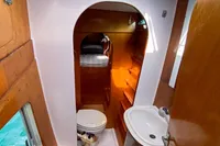Compact bathroom in 2004 Custom BBL 54' boat with wooden accents and porthole window.