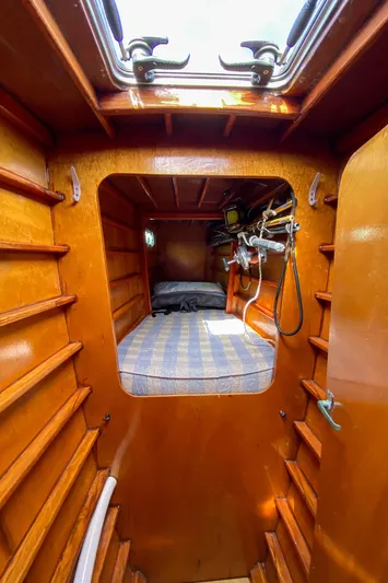  Yacht Photos Pics Wooden interior cabin of a 2004 Custom BBL 54' boat with a cozy bed.