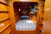 Wooden interior cabin of a 2004 Custom BBL 54' boat with a cozy bed.