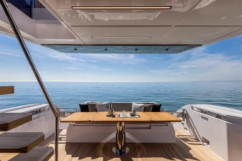 Our Trade Yacht Photos Pics Luxurious 2024 Ferretti Yachts 580 deck with ocean view and elegant dining setup.