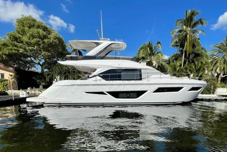 Our Trade Yacht Photos Pics 2024 Ferretti Yachts 580, sleek design, docked by palm trees under blue sky.