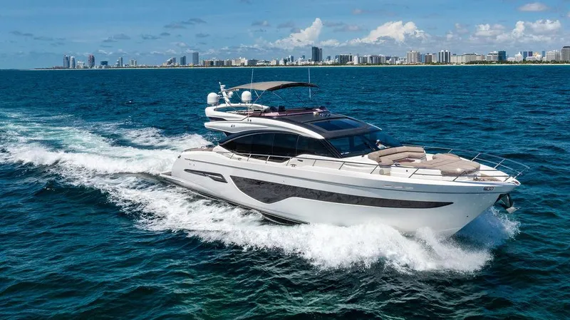 Cocoon Yacht Photos Pics Luxurious 2021 Princess S78 yacht cruising on blue ocean near city skyline.