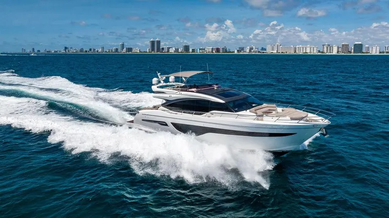 Cocoon Yacht Photos Pics Luxury Princess S78 yacht cruising on open sea, city skyline in background, 2021 model.