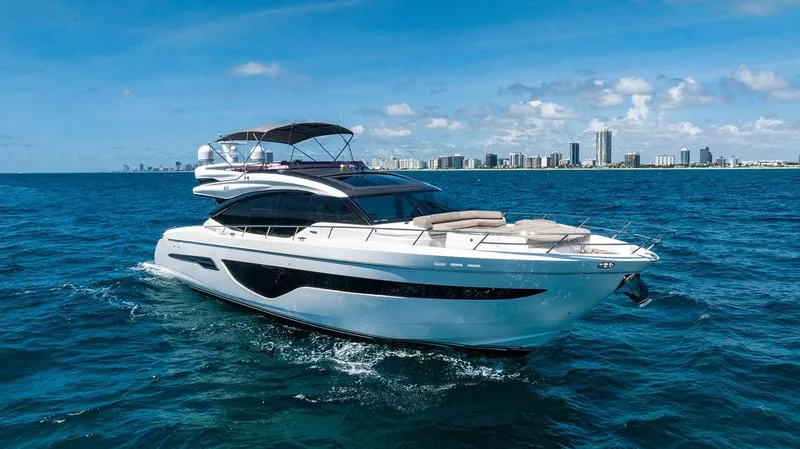 Cocoon Yacht Photos Pics Luxurious 2021 Princess S78 yacht cruising on blue ocean with city skyline in background.