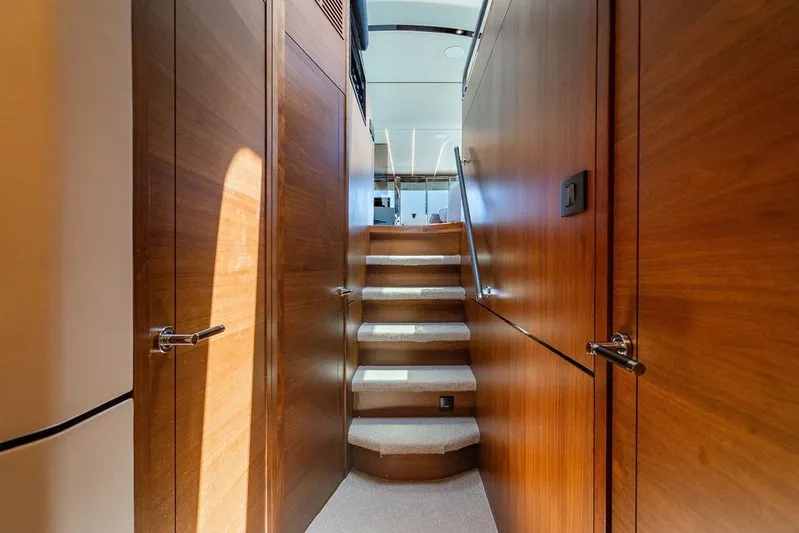 Cocoon Yacht Photos Pics Interior of 2021 Princess S78 yacht with wooden walls and carpeted stairs.