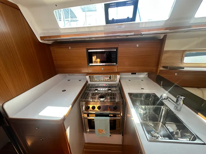 C426 #115 Yacht Photos Pics Modern yacht kitchen with wood cabinetry, stainless steel appliances, and dual sinks in a Catalina 426.
