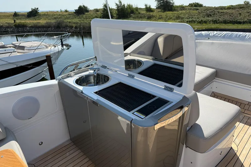 F50199 Yacht Photos Pics Outdoor kitchenette on 2024 Princess F50 yacht with sink and grill, docked by water.