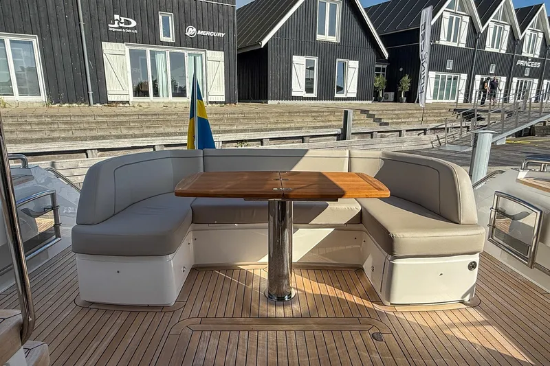 F50199 Yacht Photos Pics Luxury seating area on 2024 Princess F50 yacht with wooden table and Swedish flag.