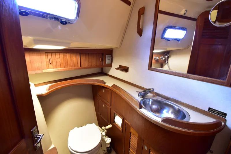 Promises Yacht Photos Pics Luxurious 1998 Island Packet 350 yacht bathroom with wooden cabinetry and stainless steel sink.