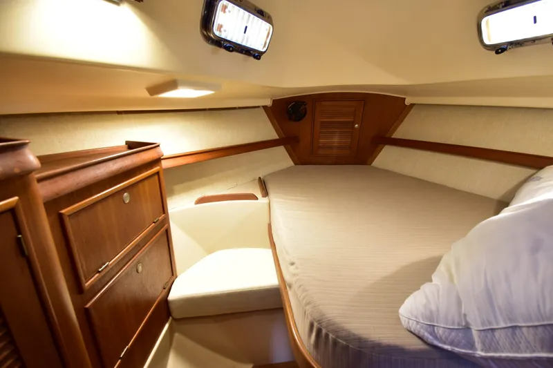Promises Yacht Photos Pics Cozy cabin interior of 1998 Island Packet 350 sailboat with wooden cabinetry and comfortable bedding.
