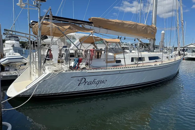 Pratique Yacht Photos Pics Outbound 46 sailboat from 2012 docked at a marina, featuring tan sails and sleek design.