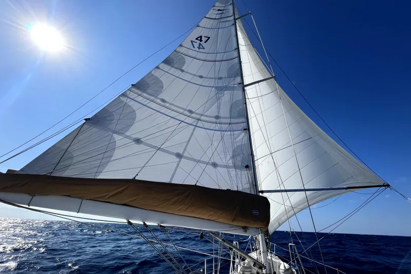 Pratique Yacht Photos Pics Sailing yacht Outbound 46, 2012 model, with full sails under a clear blue sky.
