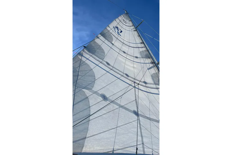 Pratique Yacht Photos Pics Sail of a 2012 Outbound 46 yacht against a clear blue sky.